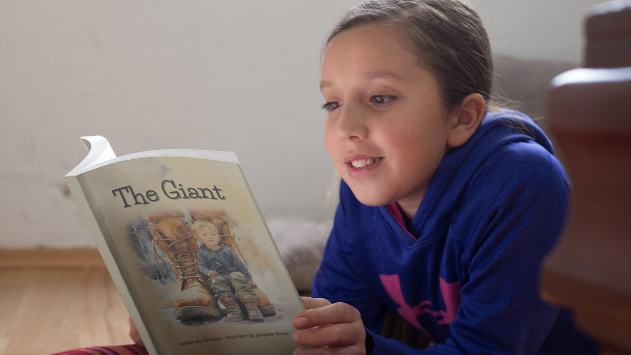 Young girl on the floor reading The Giant